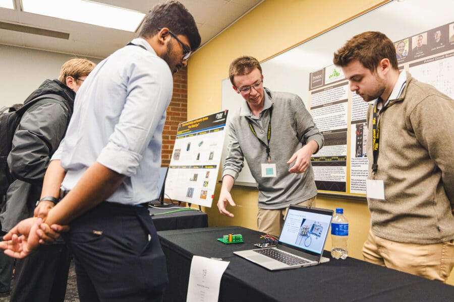 Attendees look at a laptop