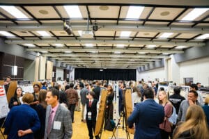 A group of people standing together in a room, engaged in conversation and interaction.