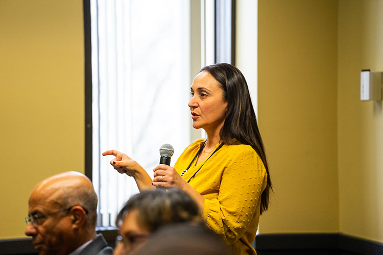 Amanda Zelechoski stands and speaks into a microphone.
