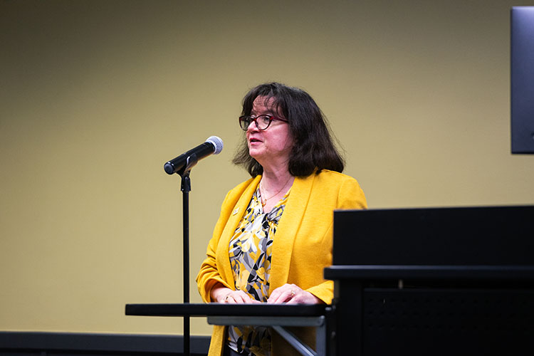 PNW Provost Marie Mora speaks into a microphone