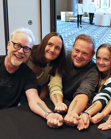 A family poses with Adam Savage.
