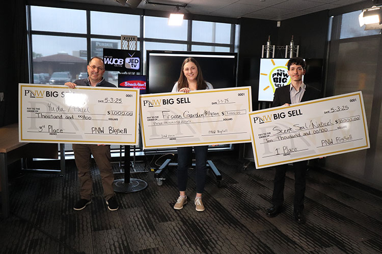 Big Sell winners pose with commemorative checks in a media studio