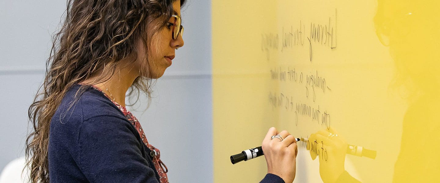 Female writing on a smart board