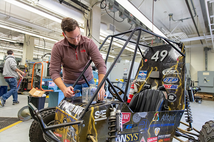 A student works on a Baja race car