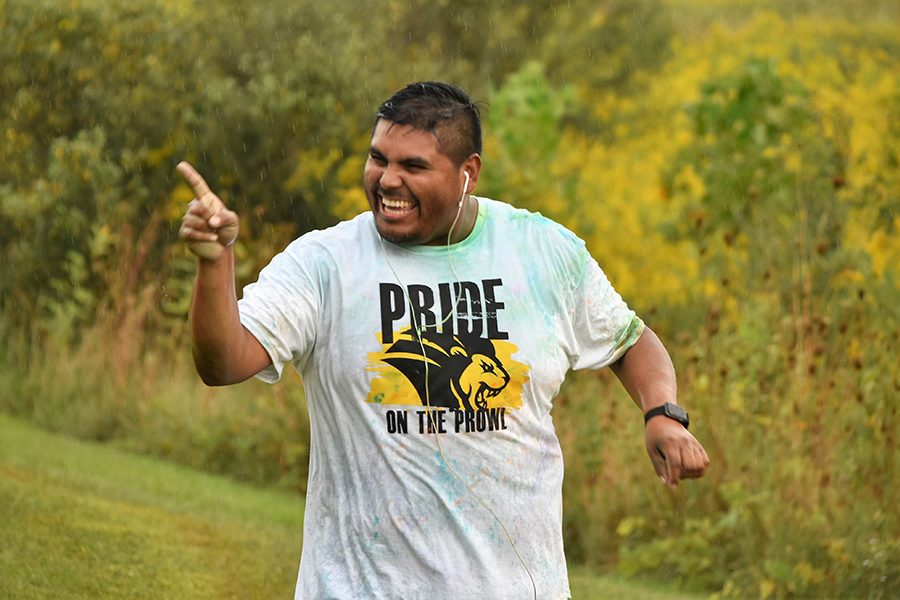 A runner points a finger at the PNW pride stride.