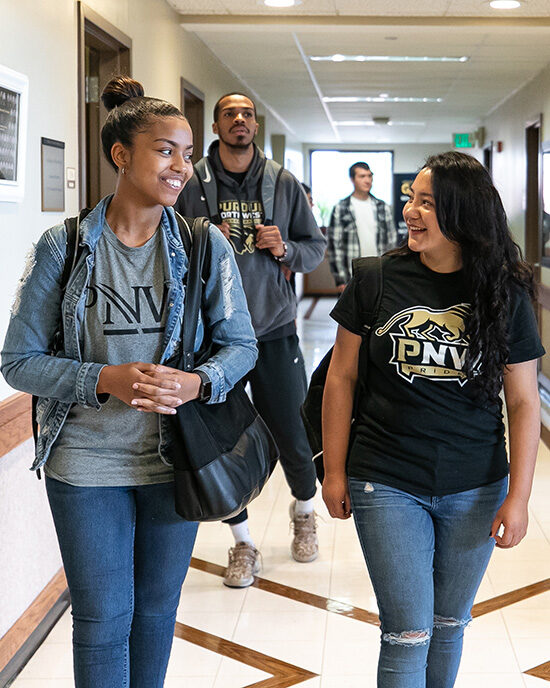 PNW students walk down a hallway.