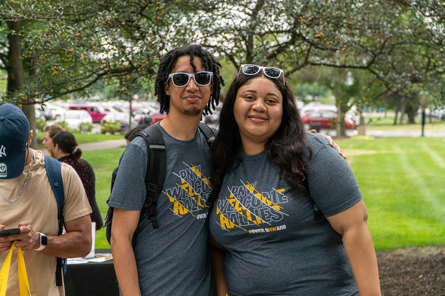 Two people pose together in welcome week t-shirts