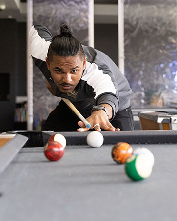 A PNW student lines up for a pool shot.