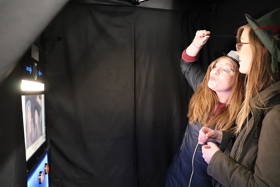 Two students pose in a photo booth