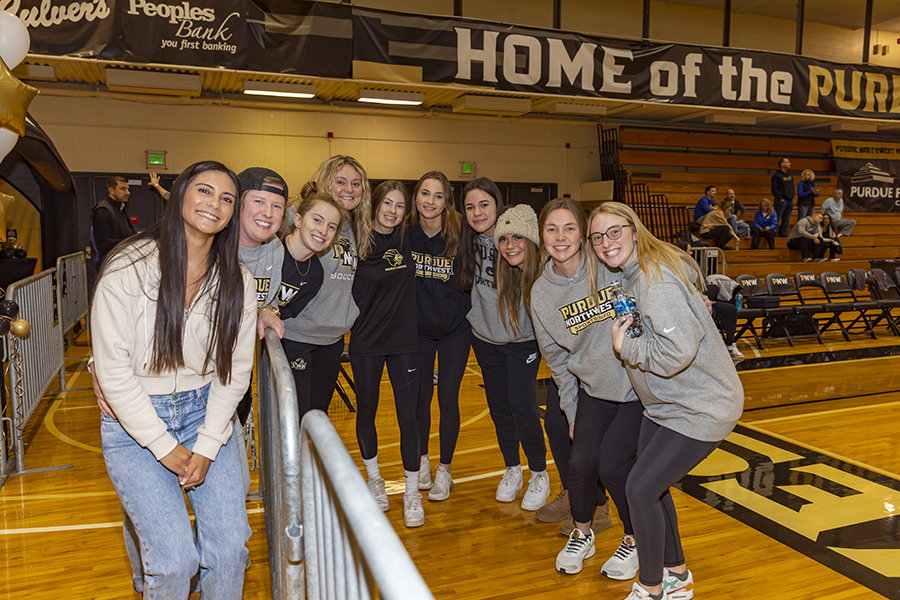 A group of students pose together on the basketball court