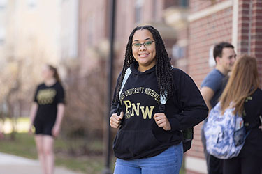 A PNW student in a sweatshirt outdoors