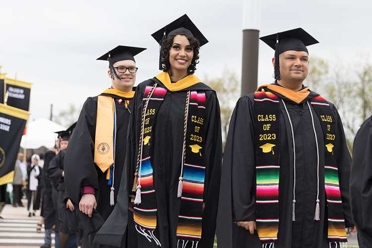 PNW first-gen students with silver cords at commencement.