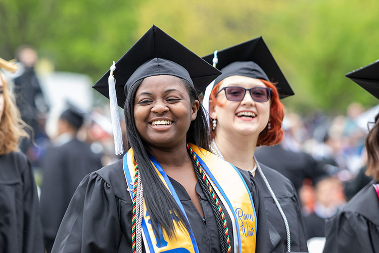 PNW first-gen students with silver cords at commencement.