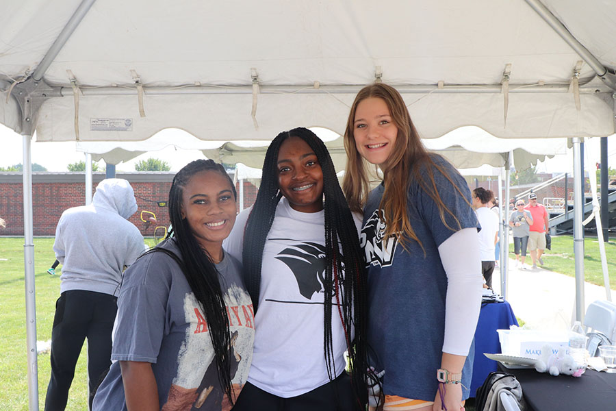 Three students stand together at the Homecoming Sports Festival