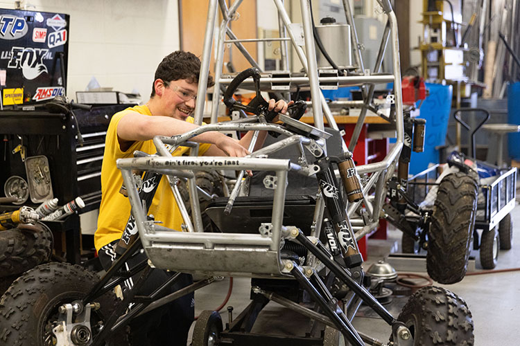A student works on a baja racing car