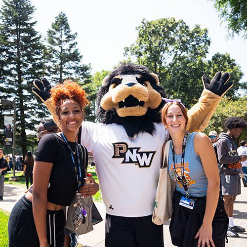 Two students pose with Leo the Lion