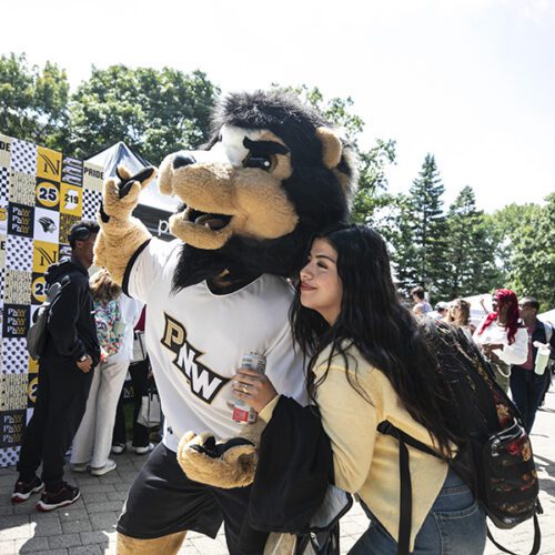 Fall 2025 Welcome Rally, student posing with Leo the Lion