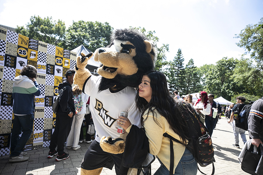 Fall 2025 Welcome Rally, student posing with Leo the Lion