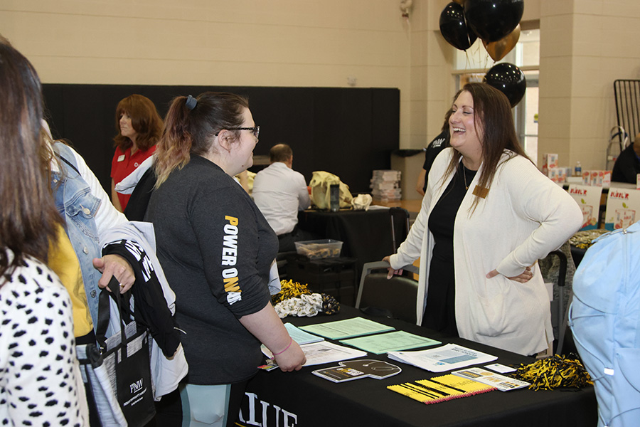 Fall 2025 Welcome Rally in Westville, a student talking to a faculty member at a table