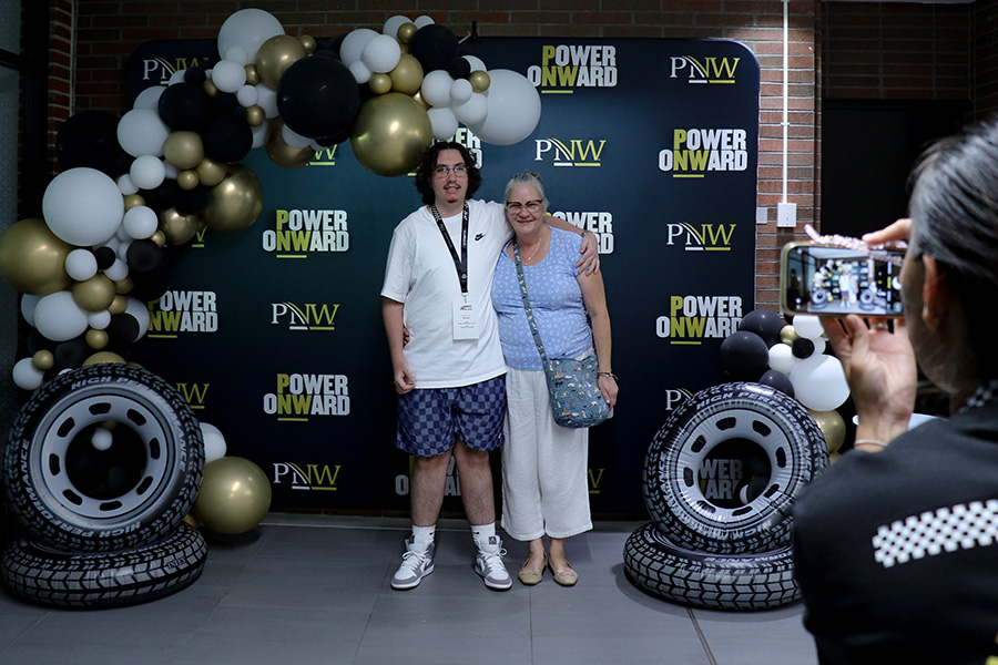 PNW NSO, A student and their relative taking a photo in front of the backdrop