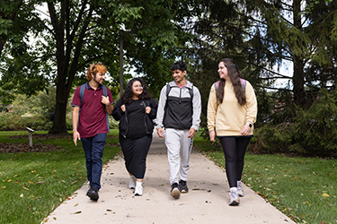 4 students walking outside on a sidewalk on the PNW Hammond Campus