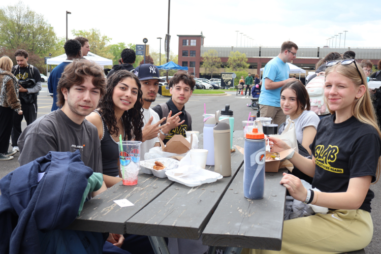 PNW students sitting at a picnic table eating food