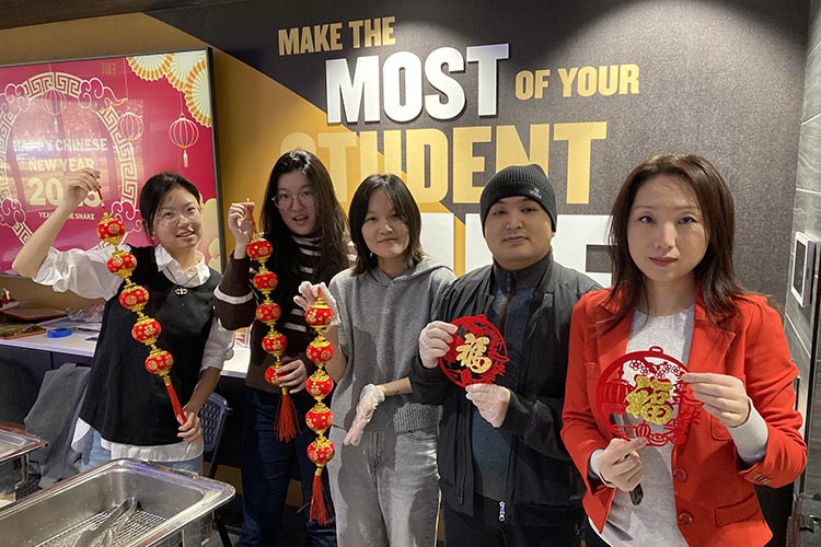 PNW students celebrating Lunar New Year while holding cultural objects