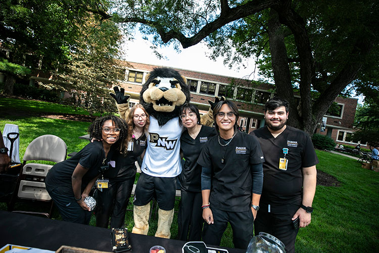 Five nursing students pose with PNW's mascot Leo the Lion