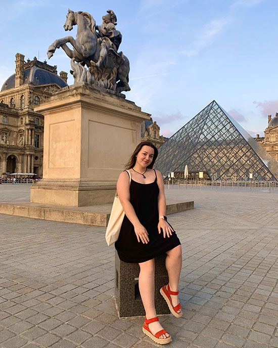A PNW student posing in front of the Louvre in Paris.