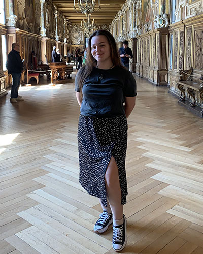 PNW student, Cassie Vickers, stands in a hallway in France