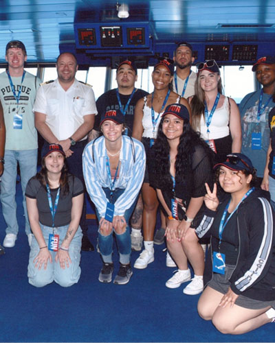 Students pose with their captain during a study away cruise