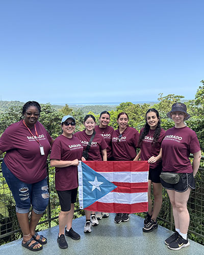 PNW Students and professors hold up a Puerto Rican flag.