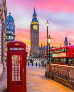 Big Ben tower of Houses of Parliament with telephone booth, Westminster in London, UK at sunrise.