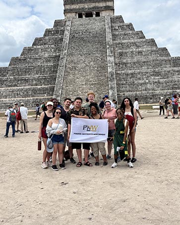 PNW students standing in front of a structure in Mexico.