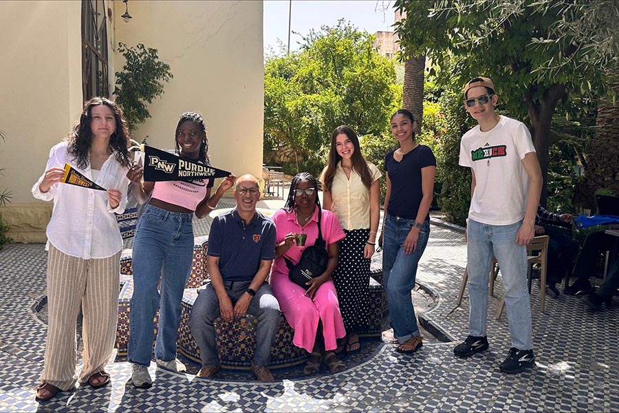 A group of PNW students holding up Purdue Northwest flags in Morocco for the Summer Study Away program.