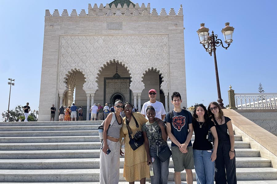 A group of PNW students standing in front of a white building in Morocco for the Summer Study Away program.
