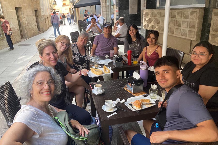 A group of PNW students and faculty sitting at a table together while in Spain for the Study Away Summer program.