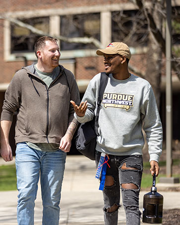 Two veterans walk outdoors on the PNW Hammond campus