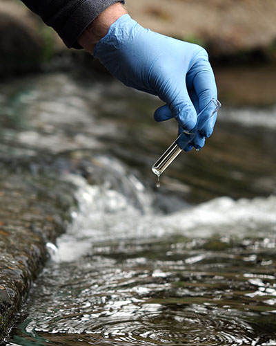 Gloved hand into the water collecting tube.
