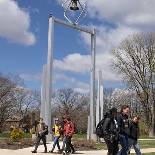 PNW students walk past the Bell Tower