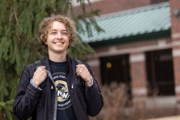 A PNW student stands outdoors