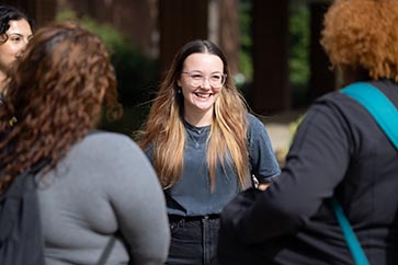 Four students talking with one another outside on the PNW campus 363x242
