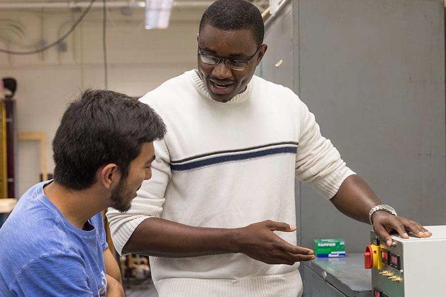 Professor showing a student a piece of equipment