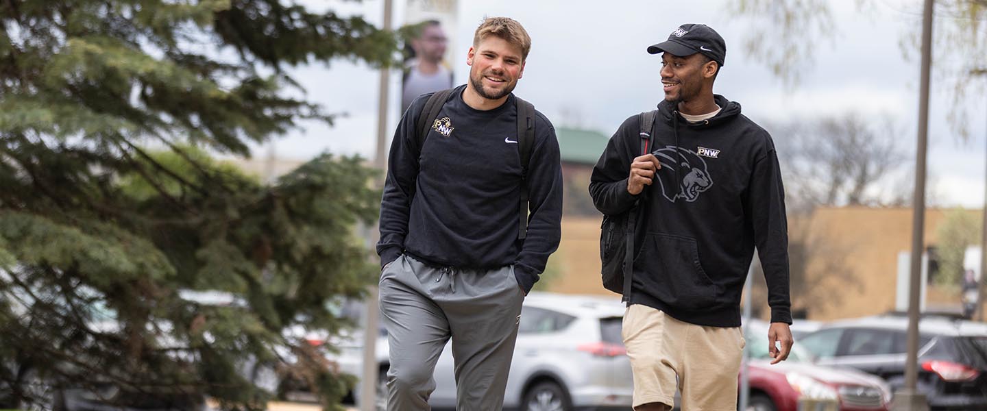 Two PNW students walking and talking on campus