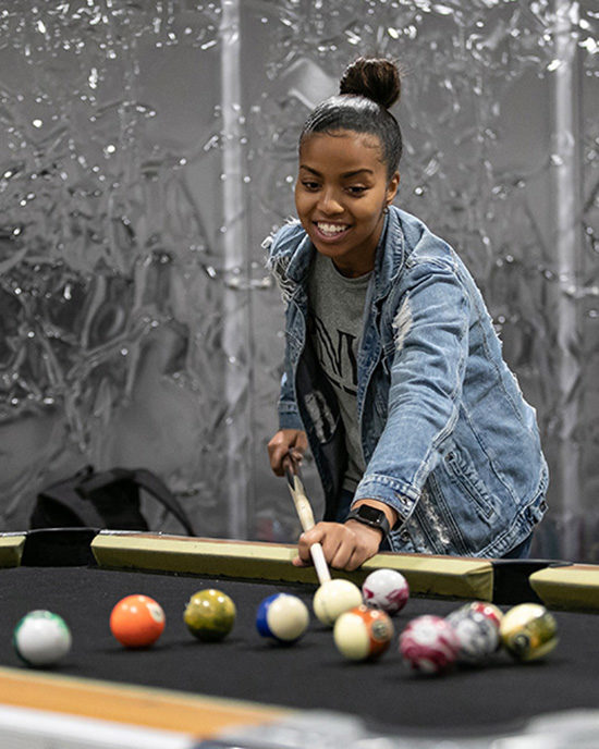 A PNW student plays pool.
