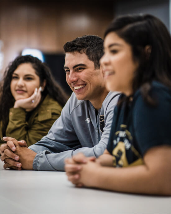 group of smiling students sitting at a table