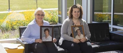 Marily (left) and Jennifer Martz pose with each other's graduation photos.