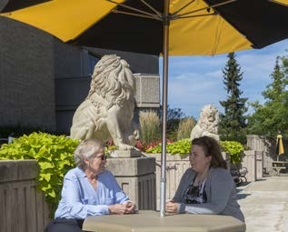 Marilyn (left) and Jennifer Martz sitting under an umbrella