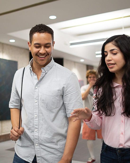 Two students walk down a hallway together