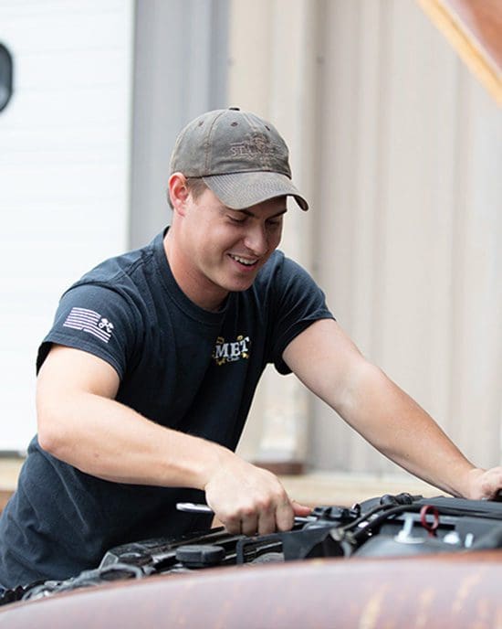 A student works on a car for a PNW club